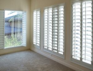 Empty room with white shutters on window